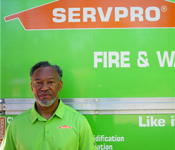 SERVPRO employee pictured in front of green background