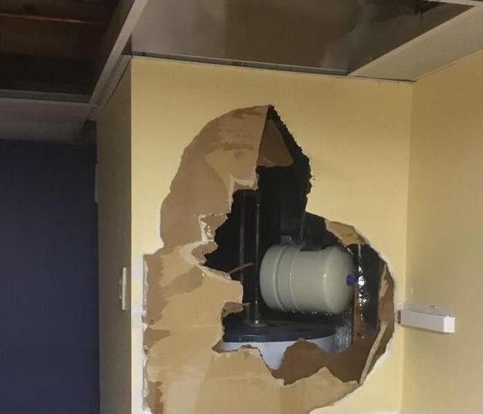 water tank exposed by drywall damage